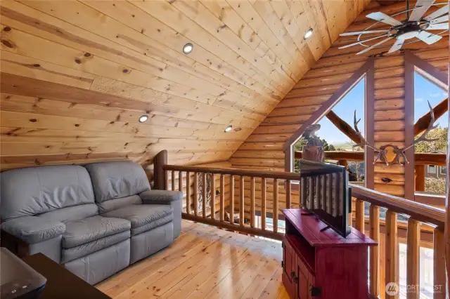 Sitting area within the loft.  Eye appealing overhead fan as well as a great amount of can lighting throughout the ceiling.