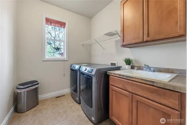 This spacious and functional laundry room offers convenience and style with these sleek brand new Maytag front-loading washer & Dryer.