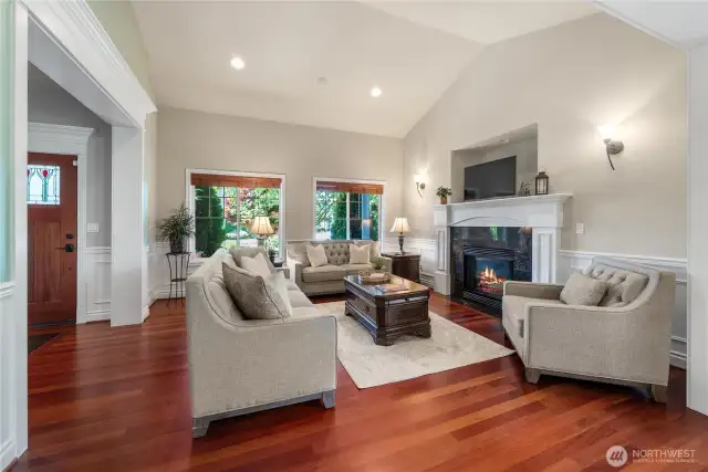 Step into this elegant and inviting great room featuring souring ceilings, rich hardwood floors, and an abundance of natural light streaming through large picture windows.
