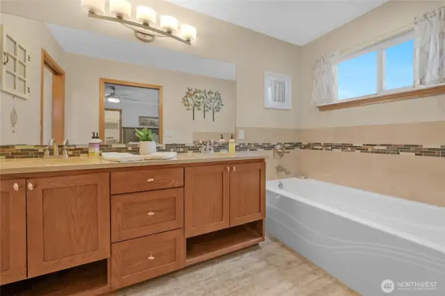 The bathroom in the primary bedroom is tastefully updated with a double sink vanity, large soaking tub, and a wonderfully relaxing shower.