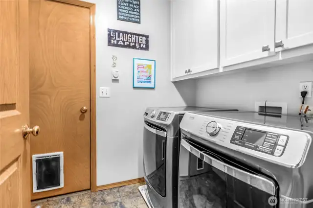 This utility room located just off the garage features an abundance of cabinetry and a utility sink area.