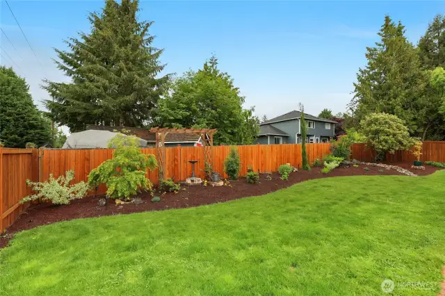 Beautiful, sunny, and fully fenced backyard with wonderful landscaping.