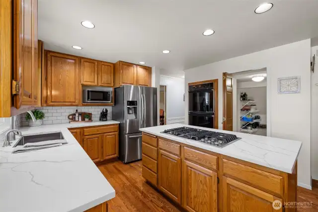 Subway tile backsplash. Undermount sink with instant hot water. Gas cooktop, double oven. All kitchen appliances stay with the home.