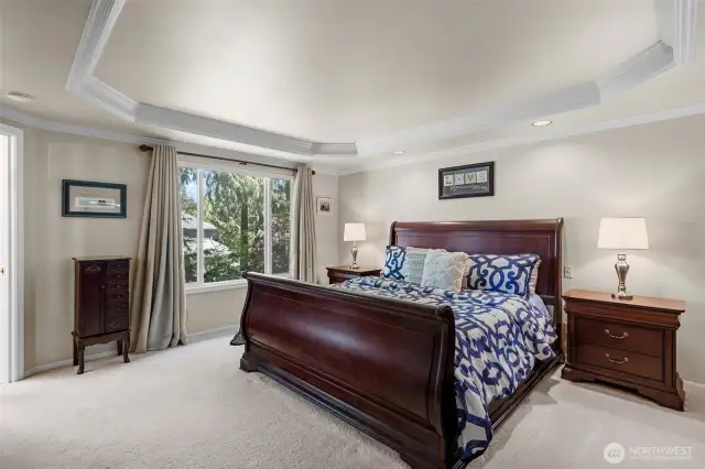Double doors lead to the spacious primary retreat with coffered ceiling and custom mill work.