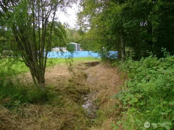 Nearly year round creek at east side of level area.