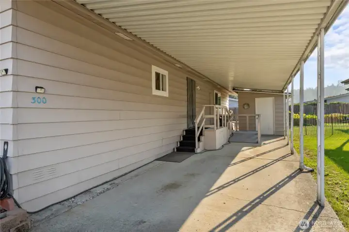 Two Car carport with wheelchair access ramp and large storage shed.