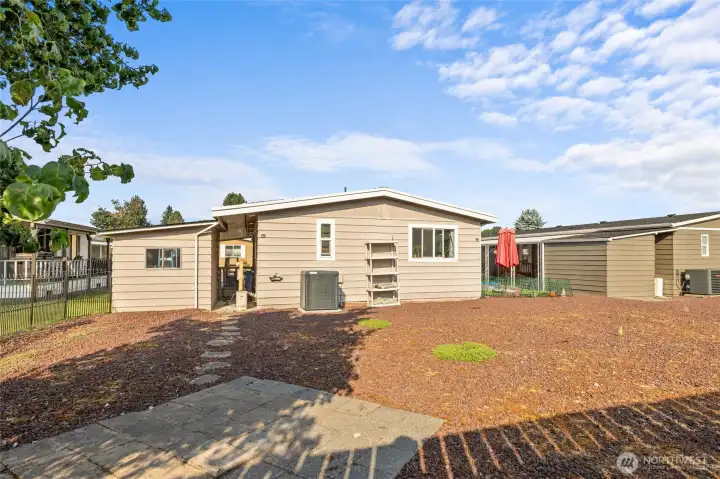 Another view of back yard, pavers in place for your firepit or extra hang out area, looking back at home and New Heat Pump, storage shed and path to back patio carport.