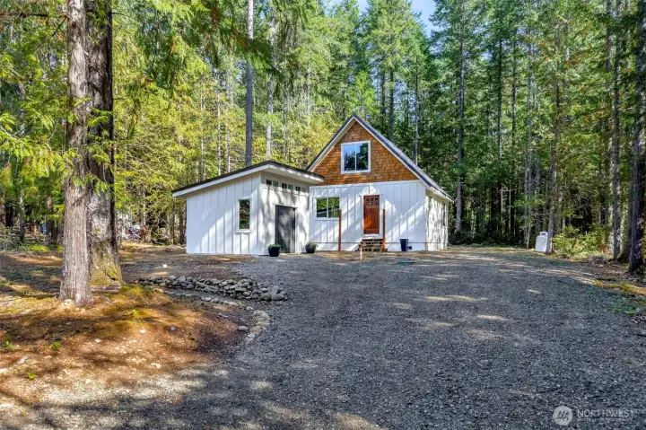 Outbuilding is 12' x 11' +/- with laundry hookup and storage.