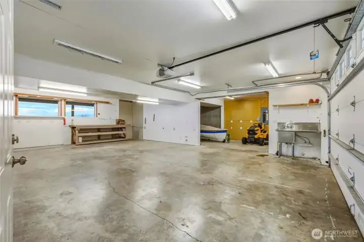 Huge attached garage, room for 4 cars, utility sink, EV charging, wired for generator, entrance to backyard.