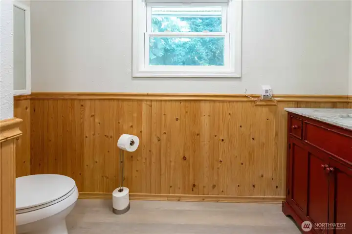 Bathroom with wood paneling and red cabinets