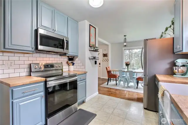 Kitchen view to dining room, I love the butcher-block countertops and full tile backsplash.