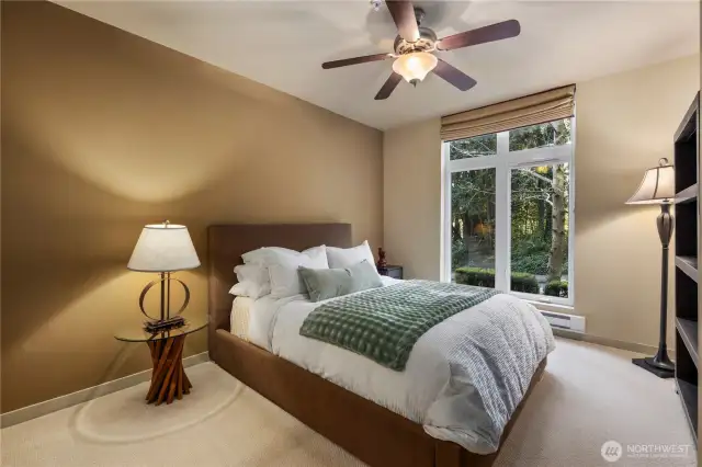 Comfortable, primary bedroom with plush carpeting and large windows, provides a peaceful retreat.