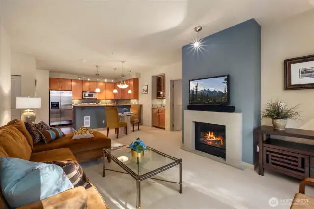 The inviting living room is designed for comfort and entertainment, featuring a mounted TV, sound system, and a cozy gas fireplace that creates the perfect ambiance. Whether you're unwinding or entertaining guests, this space offers both warmth and modern conveniences.