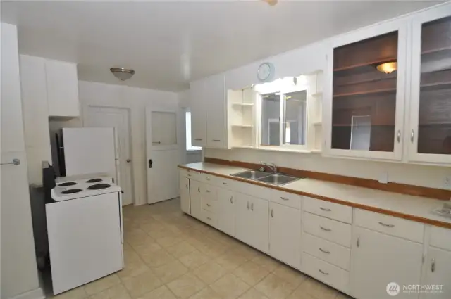Front house kitchen is quite large with tons of storage space and room for a table and chairs.