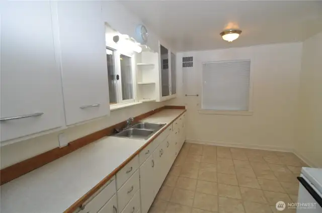 Front house kitchen showing the long counter and space for table.