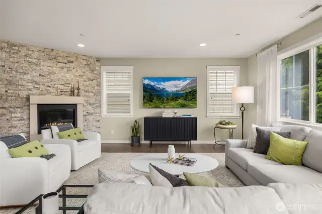 Large family room surrounds floor to ceiling gas fireplace