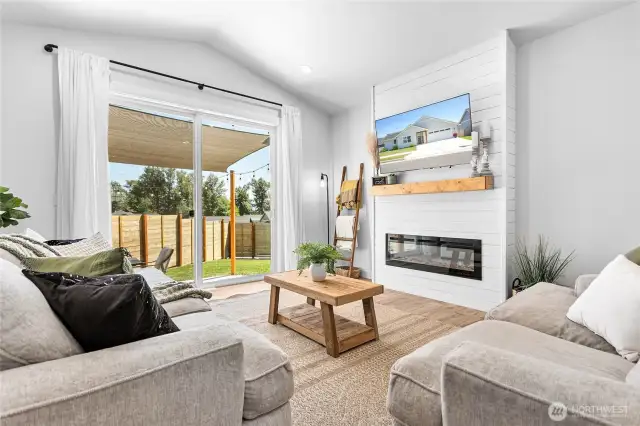 Vaulted living room w/shiplap fireplace & extra-large sliding glass door to backyard