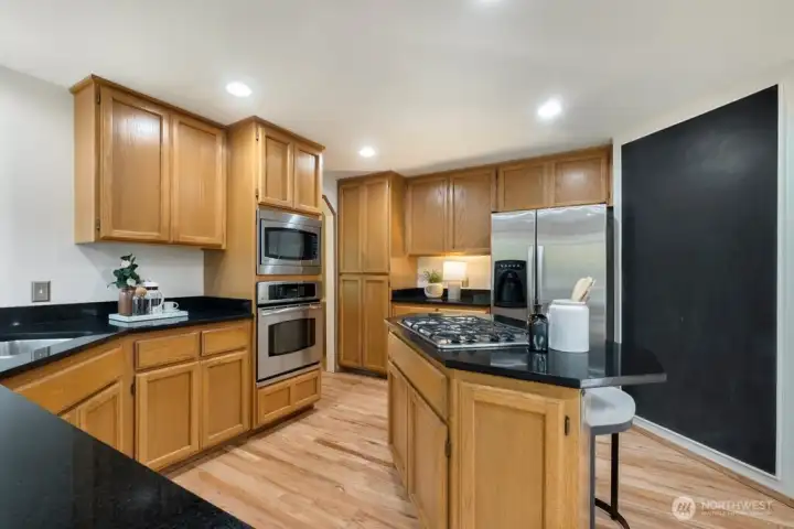 Granite countertops and solid wood cabinets and cool blackboard wall to write grocery lists, meal plans and notes to your family