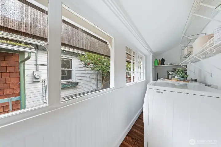 Sun-filled laundry room with ample space to wash, fold, and organize, complemented by privacy shades for added comfort. Stackable ready for more space.