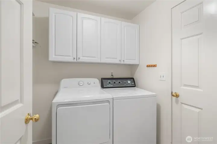 Dedicated laundry room between the entry and garage. Additional storage space behind the door to the left.