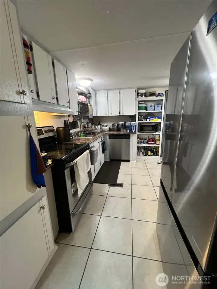 Walking into the kitchen from the living room.  New refrigerator.