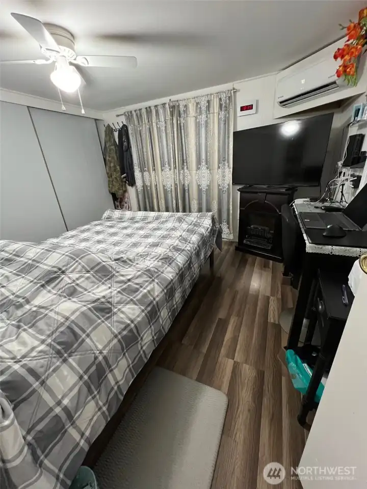 Bedroom #1.  Enclosed sunroom beyond the curtain.  Hot water tank located behind a wall.