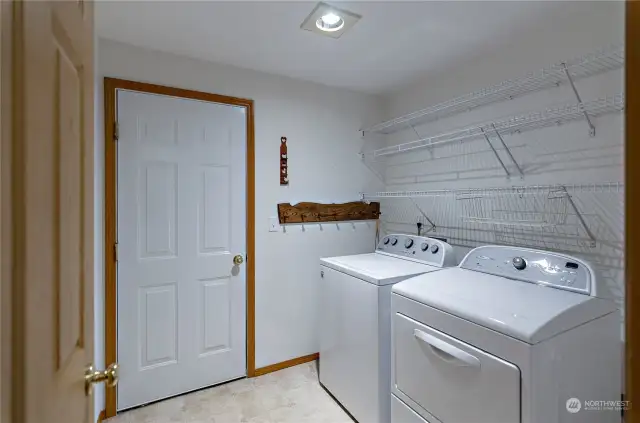 Utility room, complete with washer and dryer.   Door leads to two car garage.