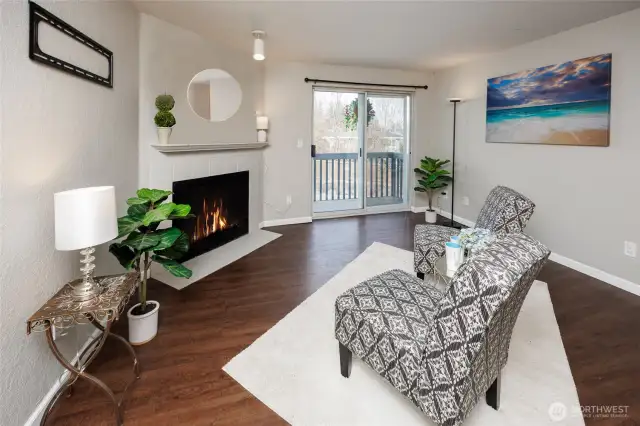 Warm & inviting living room offering a cozy wood-burning fireplace, & a deck with storage.