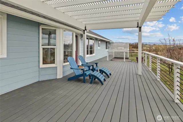The newly added Trex deck with metal cable railing and pergola creates a spacious and stylish outdoor living area.