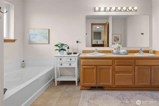 Double sink vanity, bath tub and separate shower in primary bath.