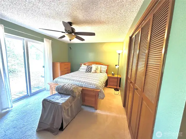 Primary bedroom with sliding glass door out to back yard that borders the golf course. Oversized closets.