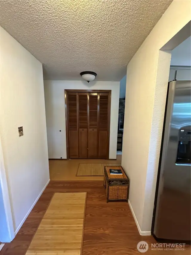 Entry hallway, laundry room to the left and kitchen to the right