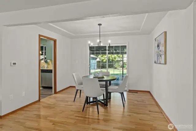 Dining room with sliders to the spacious, fully-fenced backyard with mature landscaping.