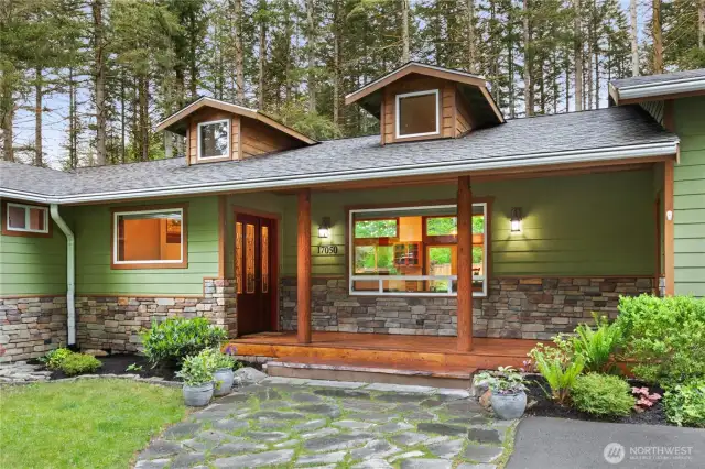 Enjoy coffee on the covered front porch with stone accents and wood beams