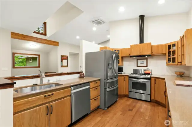 Decked out kitchen with custom cabinets, hardwood floors, ss appliances and recycled glass countertops