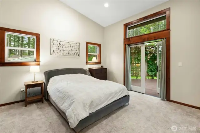 The primary bedroom features vaulted ceilings and French doors