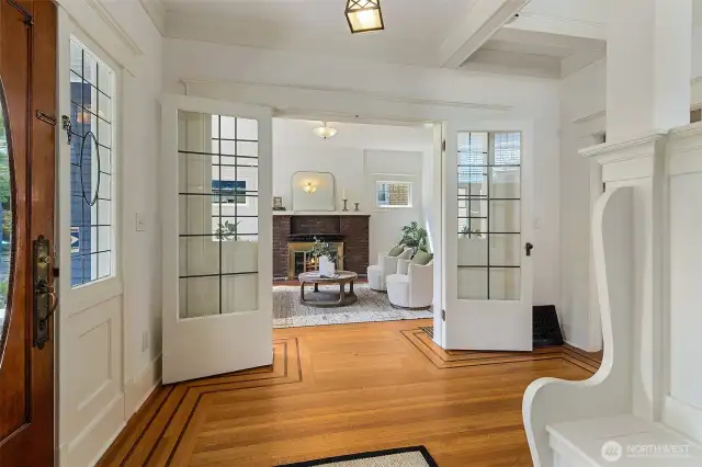 French doors open to the living room centered on the fireplace.