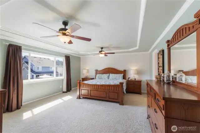 The spacious primary suite is a relaxing retreat, featuring two ceiling fans, coved ceiling, and crisp white trim. Enjoy the convenience of a walk-in closet and a private en suite bathroom for your own personal sanctuary.