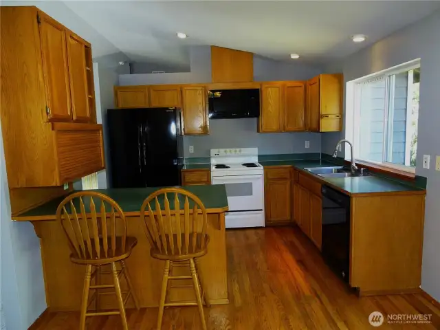 Kitchen With Eating Bar and Lots Of Storage Space. Oak Hardwood Flooring.
