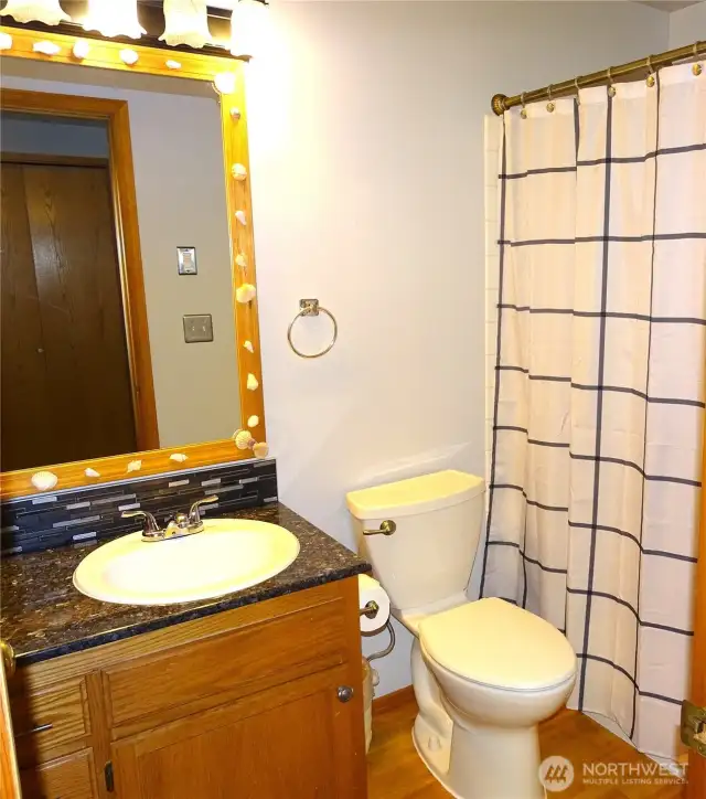 Main Bathroom With Oak Hardwood Floor and Granite Countertop.