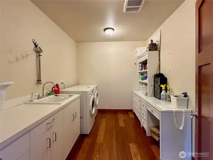 Main floor laundry room complete with storage and sink.