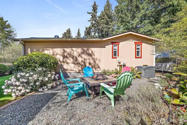 The side of the home has a firepit and space for gathering.   Yes, there's also a heat pump, with A/C.