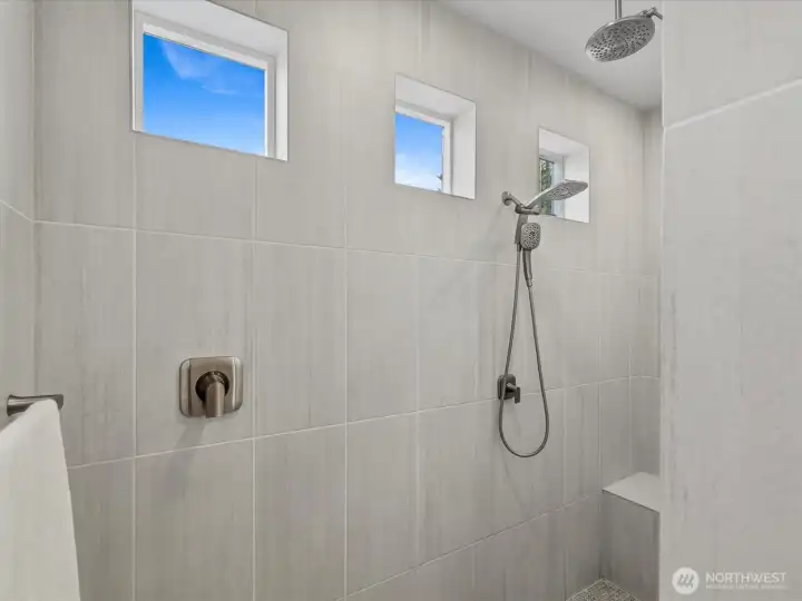Primary bathroom features a spacious walk-in shower with natural light (no tub).