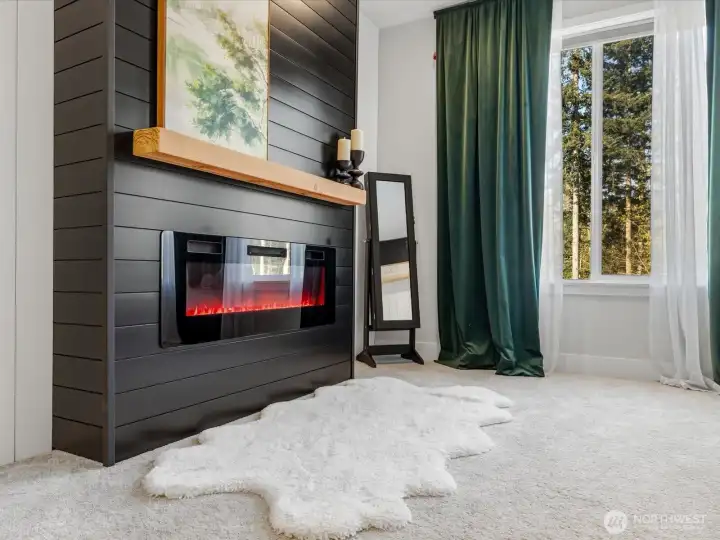 Primary bedroom features an electric fireplace.