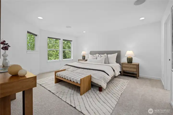 Set apart from the other bedrooms for a quieter sense of privacy, the primary suite still remains on the same floor, keeping everyone close. Large north-facing windows with blinds bring in soft natural light without the stronger morning sun, while recessed ceiling lights keep the room evenly and gently lit. Plenty of outlets add everyday ease, and the built-in speaker system carries music here just as it does throughout the home.