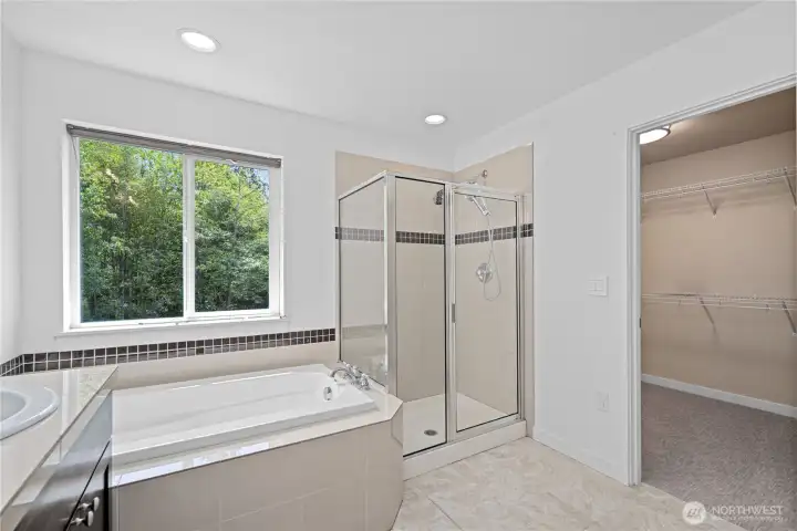 Framed in glass, the walk-in shower feels open and easy to step into, with two shower heads, including a rain shower above, bringing a more spa-like start and finish to the day. Just beyond, the oversized walk-in closet gives you room not only for extensive storage, but also the ease of dressing right there beside the bath.
