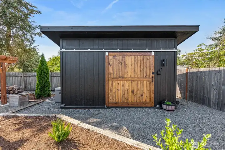 High-quality custom shed with charming stained barn door access on the exterior