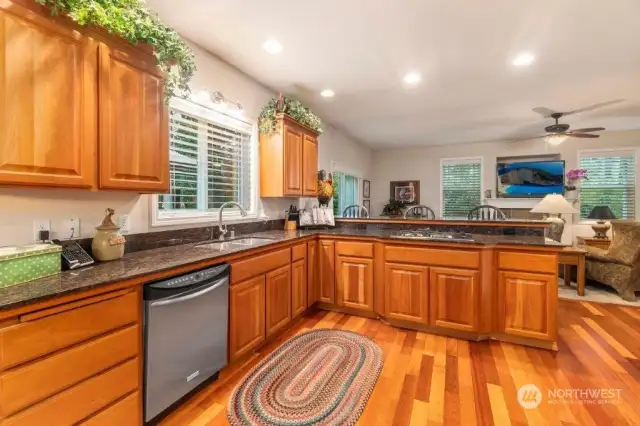 The kitchen is beautiful with it's cherry wood floors and cabinets, and long granite counters. But it's a joy to cook in as well, with the propane cooktop and double oven, and long granite counters. The family room is on the other side of the raised counter.