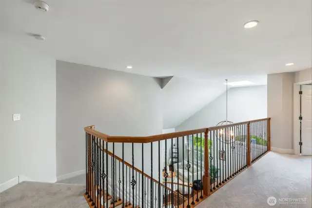 Second level landing leading to a primary suite and three additional spacious bedrooms plus bonus room.