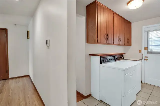 Laundry room sits right behind the kitchen, door leads to the side yard, off to the right is a 3/4 bath.
